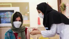 تزریق واکسن کرونا به یک دختر دانش‌آموز در مدرسه‌ای در تهران، پایتخت ایران