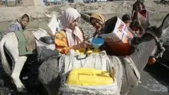 girls load water containers