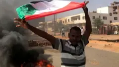 Uwigaragambya muri Sudan azunguza ibendera