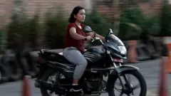 मोटरसाइकल चलाउन सिक्दै एक युवती।