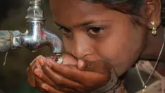 నీరు తాగుతున్న బాలిక