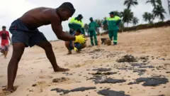 Homem limpando uma praiasite aposta 365Camaçari, Bahia