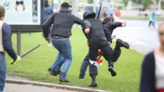 Unidentified people holding batons chase a man in an attempt to knock him down during an opposition rally to protest against police brutality and to reject the presidential election results in Minsk, Belarus September 6, 2020.