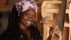 Binette pose avec ses outils de travail