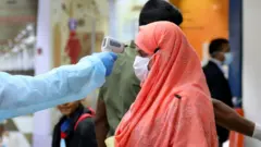 শরীরের তাপমাত্রা পরীক্ষা করা হচ্ছে।