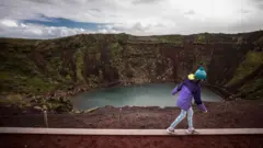 Niña camina frente a un cráter en Islandia.