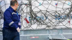 Aeroport işçisi Sputnik V vaksini fonunda