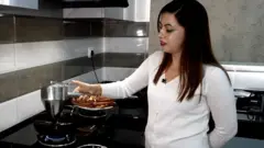 घरमै मेसीनको प्रयोग गरेर सेलरोटी बनाउँदै एक महिला।