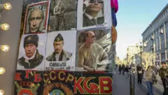 Photos of Russian President Vladimir Putin are displayed at a souvenir shop in downtown Moscow, Russia, 25 February 2022
