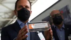 Doria exibe a CoronaVac ao lado de Dimas Covas