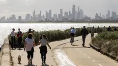 People walk and ride along the beach at Brighton