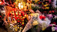 火災現場の外に置かれた花束やキャンドル