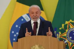 Lula falando no púlpito com várias bandeiras do Brasil ao fundo