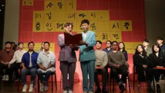 기자회견장에서 준비해온 발표문을 읽는 김조광수-김승환 부부