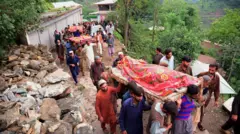 سكان يحملون نعوش ضحايا فيضانات ناجمة عن أمطار في مظفر آباد عاصمة الشطر الباكستاني من كشمير