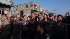 عائلة وأصدقاء الصحفي حسام شبات يحملون جثمانه، بعدما قتل في غارة إسرائيلية في شمال قطاع غزة بحسب تصريحات الدفاع المدني الفلسطيني. في الصورة جمع من الناس.