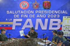 Maduro sentado diante de mesa com militares