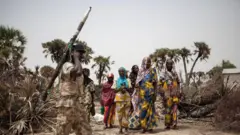 Aworan ologun to gbe ibọn dani ati awọn obinrin araalu