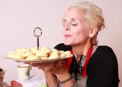 یوه مېرمنه چې لاس کې یې د کلچو بشقاب دی