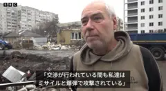 白髪のウクライナ人男性が、険しい表情で前方を見ている