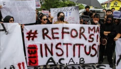 Massa yang tergabung dalam Aliansi Barikade membentangkan poster saat berunjuk rasa terkait kasus penembakan warga sipil oleh oknum polisi di depan Polda Kalteng, Palangkaraya, Kalimantan Tengah, Kamis (19/12/2024).