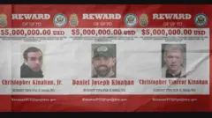 Cartaz de recompensa do FBI, em vermelho e branco com diversas insígnias e logotipos federais dos Estados Unidos, indica Christopher Jr., Christopher Vincent e Daniel Joseph Kinahan, oferecendo uma recompensa de US$ 5 milhões por informações sobre cada um dos supostos líderes do cartel Kinahan