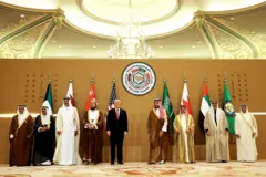 الرئيس الأمريكي دونالد ترامب، مرتديا بدلة سوداء وقميصا أبيض ورابطة عنق حمراء، يتوسط عددا من قادة دول مجلس التعاون الخليجي. ويظهر إلى يمينه ولي عهد البحرين سلمان بن حمد آل خليفة، وأمير الكويت الشيخ مشعل الأحمد الصباح، وأمير قطر الشيخ تميم بن حمد آل ثاني، ونائب رئيس الوزراء العُماني السيد أسعد بن طارق، فيما يظهر إلى يساره ولي العهد السعودي الأمير محمد بن سلمان، وملك البحرين حمد بن عيسى آل خليفة. وتظهر في الخلفية أعلام دول مجلس التعاون الخليجي الستة والعلم الأمريكي.