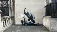伦敦皇家司法院墙上的一幅喷绘壁画,描绘了一位戴着假发的法官用法槌殴打一名抗议者。抗议者躺在地上,手里拿着一块沾满鲜血的标语牌。
