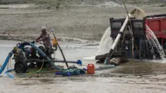 Pekerja menyedot pasir dari sungai ke atas truk menggunakan mesin di Sungai Palu, Sulawesi Tengah, Rabu (5/4)
