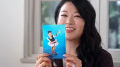 Headshot of Arden Cho smiling holding a  childhood photo
