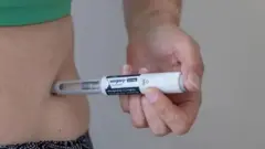 Uma pessoa aplicando uma caneta emagrecedora na barriga