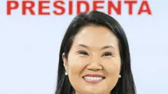 Keiko Fujimori sujeta sonriente un micrófono. Tras ella hay un cartel con el mensaje "Presidenta Fujimori". 