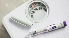 Caneta emagrecedora em cima de uma balança