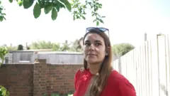 Joana no jardim de sua casa em tarde de maio