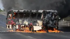 A bus burns on a highway
