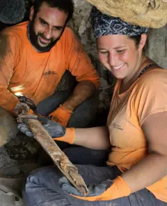 عالما الآثار حجاي هامر وأوريا عميحاي مع أحد السيوف التي عُثر عليها في كهف