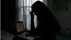 Aworan obinrin kan to n wo kọmputa ninu okunkun