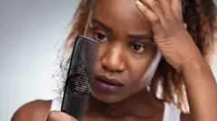 A woman shocked to see her hair stuck to a comb