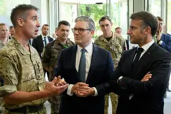 O primeiro-ministro do Reino Unido, Keir Starmer, e o presidente francês Emmanuel Macron conversam com membros das forças armadas durante uma visita militar conjunta ao Quartel-General de Northwood, em 10 de julho de 2025 em Londres, Inglaterra.