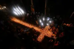 Fiéis formando uma cruz de velas em uma igreja na Bulgária