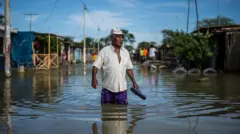 Un hombre camina por una calle inundada de Piura, en el norte de Perú 
