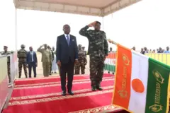 Les présidents nigérien et béninois saluant le drapeau nigérien