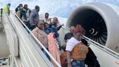Ghanian citizens coming down from di plane afta dem land for Accra from South Africa