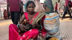 સુરતના ઉધના રેલવે સ્ટેશન પર ટ્રેનની રાહ જોઈ રહેલાં સંગીતા તેમના બાળકો સાથે