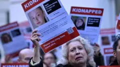 Une manifestante brandit un poster avec la photo d'une otage demandant sa libération