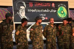 عناصر من الحشد الشعبي العراقي يقفون بالقرب من صورة للمرشد الأعلى الإيراني الراحل علي خامنئي عند مرقد الإمام الحسين، عشية مراسم تشييعه في مدينة كربلاء العراقية المقدسة، في 7 يوليو/تموز 2026.
