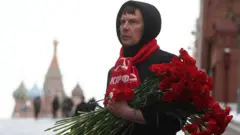  ရုရှားအာကာသယာဥ်မှူးနေ့ မတိုင်ခင် ရင်ပြင်နီမှာ ပန်းစည်းချဖို့ ရုရှားကွန်မြူနစ်ပါတီ အဖွဲ့ဝင်တွေ 