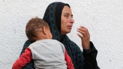 Плачущая палестинка с ребенком на руках