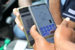 A fuel station employee double checks the fuel QR Code of a vehicle owner within the premises in Colombo, Sri Lanka, 02 August 2022.