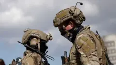 Abasirikare babiri b'Amerika bambaye imyenda yijimye ijya gusa n'ikigina.